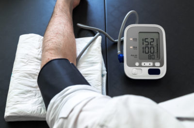 man self-monitoring of blood pressure with a tensiometer / Hypertensive patient performing a blood pressure auto test
