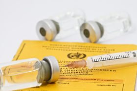 Spritze liegt auf einem Impfpass