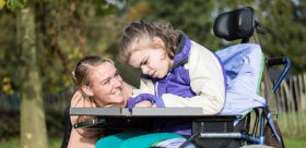 Kind im Rollstuhl mit Mutter
