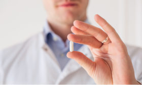 Arzt betrachtet Tablette in seiner Hand