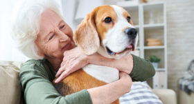 Seniorin umarmt Hund