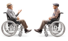 Zwei Senioren sitzen sich im Rollstuhl gegenüber